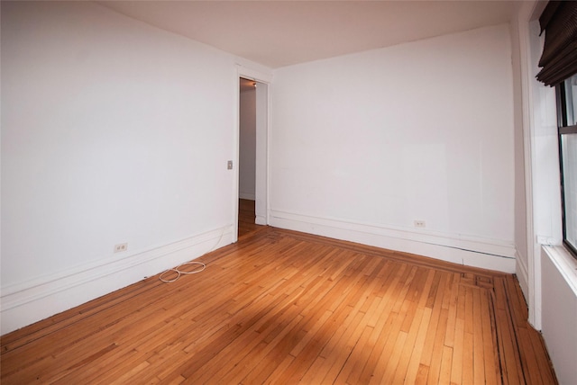 empty room with baseboards and light wood-style floors