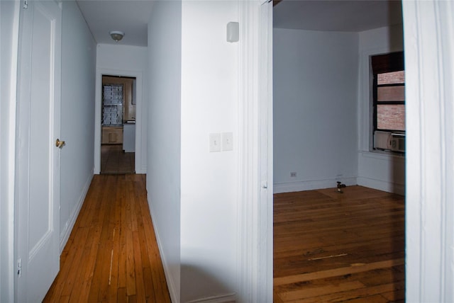 hallway with hardwood / wood-style flooring, cooling unit, and baseboards