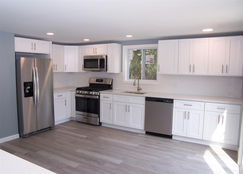 1 Hampton Rd, Shirley, NY 11967 - kitchen with stainless steel appliances, sink, and white cabinets