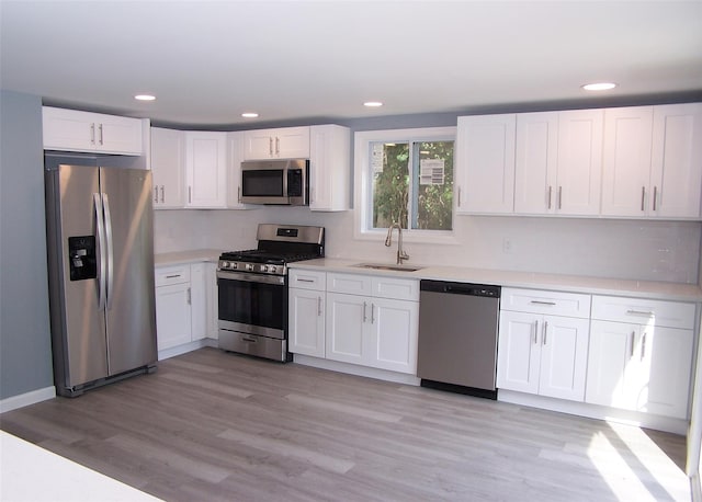 kitchen with stainless steel appliances, sink, and white cabinets