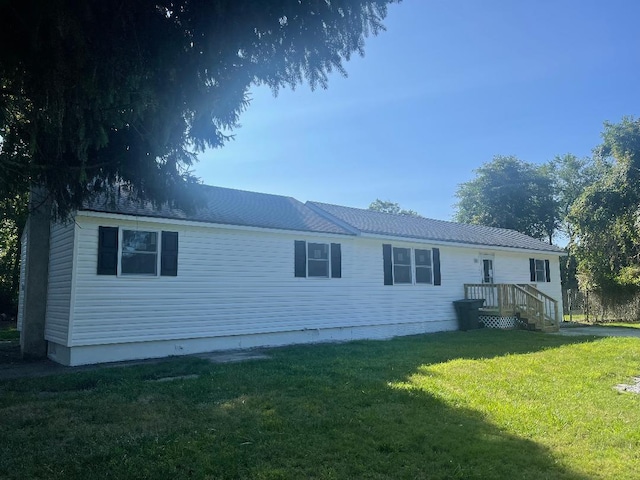 rear view of property featuring a lawn