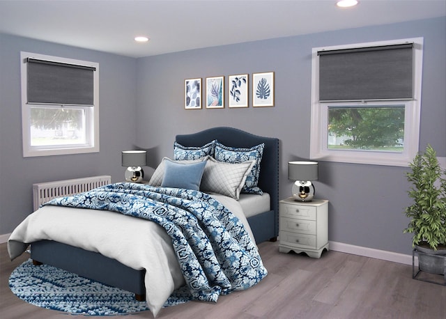 bedroom featuring radiator and hardwood / wood-style flooring