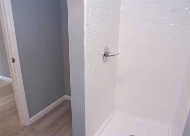 bathroom featuring hardwood / wood-style floors and tiled shower