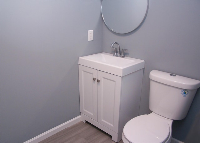 bathroom with vanity, hardwood / wood-style flooring, and toilet