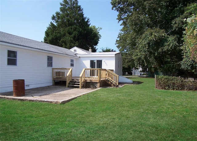 back of house featuring a wooden deck, a yard, and a patio area