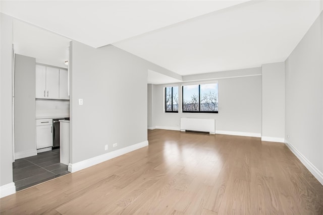 unfurnished living room with radiator and light hardwood / wood-style floors