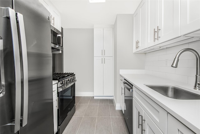 kitchen featuring stainless steel appliances, white cabinetry, sink, and decorative backsplash