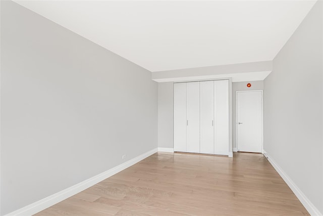 unfurnished bedroom with a closet and light wood-type flooring