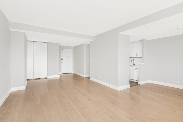 unfurnished room featuring sink and light wood-type flooring