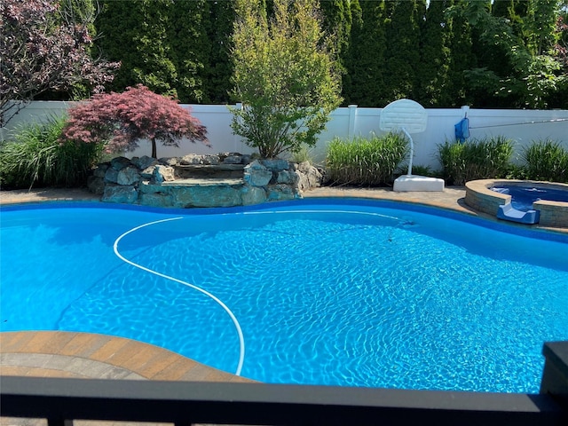 view of swimming pool with an in ground hot tub