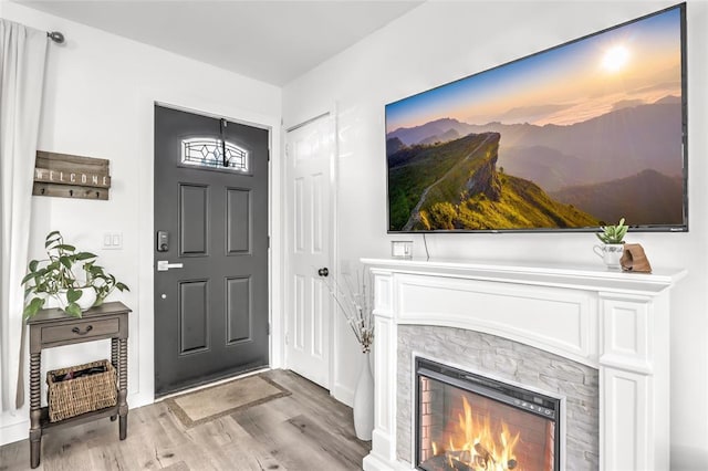 foyer with a fireplace and light wood-type flooring