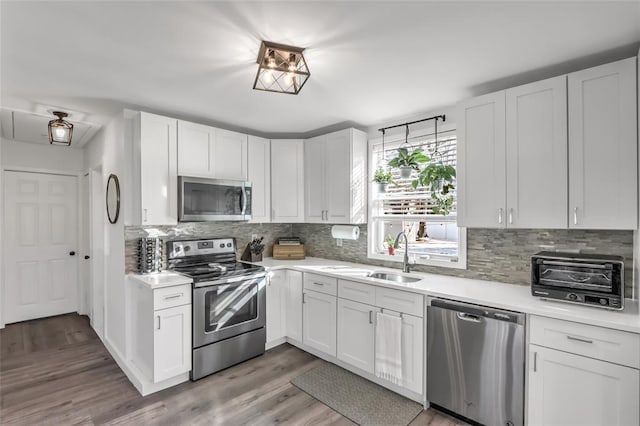 kitchen featuring white cabinetry, appliances with stainless steel finishes, sink, and dark wood-type flooring