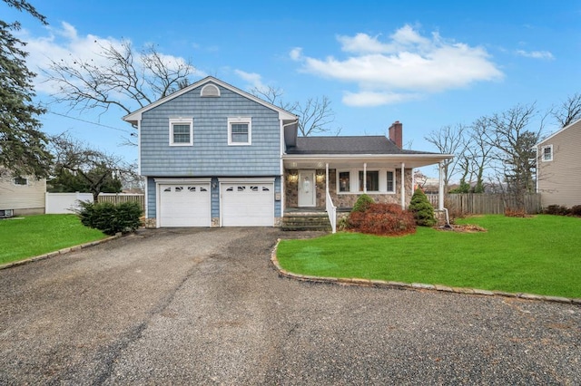 view of front of property with a garage, a front yard, and a porch