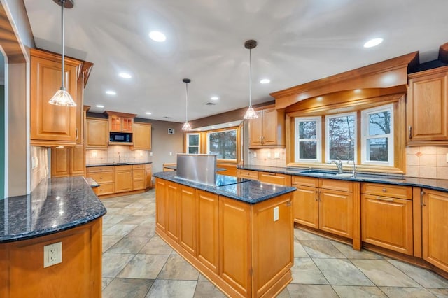 kitchen with hanging light fixtures, black appliances, dark stone counters, and a kitchen island