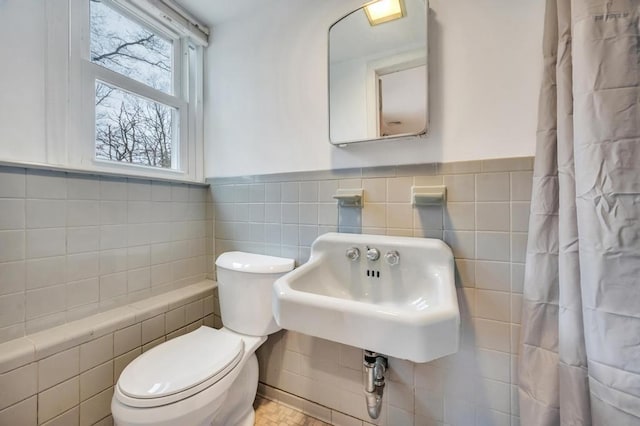 bathroom with tile walls and toilet