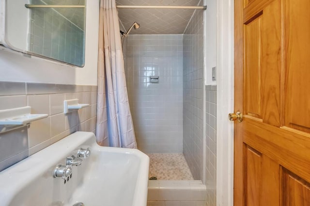 bathroom featuring tile walls, sink, and curtained shower