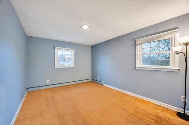 unfurnished room featuring hardwood / wood-style flooring and a baseboard radiator