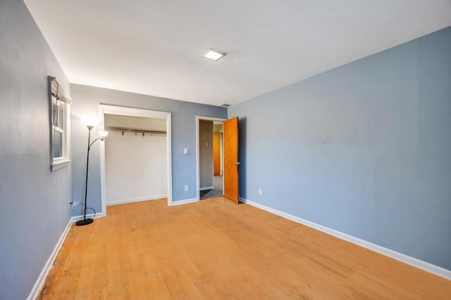 unfurnished bedroom featuring a closet and light wood-type flooring