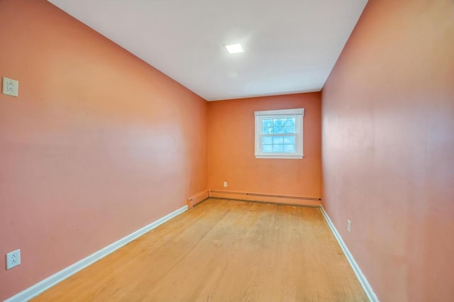 unfurnished room with light wood-type flooring and baseboard heating