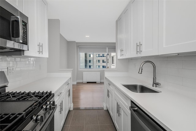 kitchen featuring white cabinetry, appliances with stainless steel finishes, sink, and backsplash