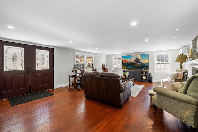 living room with dark hardwood / wood-style flooring and a wall mounted air conditioner