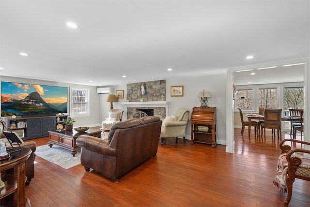 living room with hardwood / wood-style floors, a fireplace, and a wall mounted AC