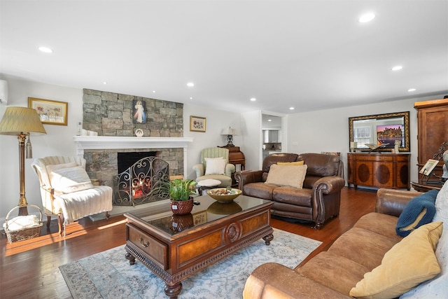 living room featuring hardwood / wood-style flooring, a fireplace, and a wall mounted AC