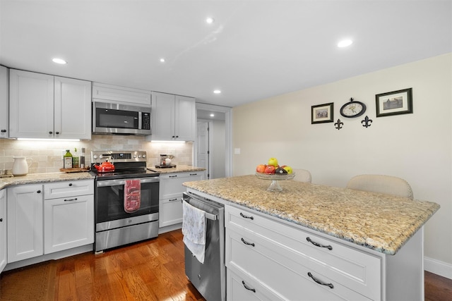 kitchen featuring appliances with stainless steel finishes, dark wood-type flooring, and white cabinets