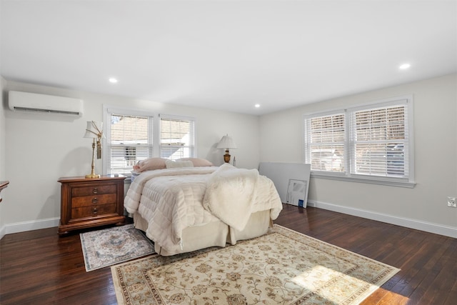 bedroom featuring dark hardwood / wood-style flooring and a wall unit AC