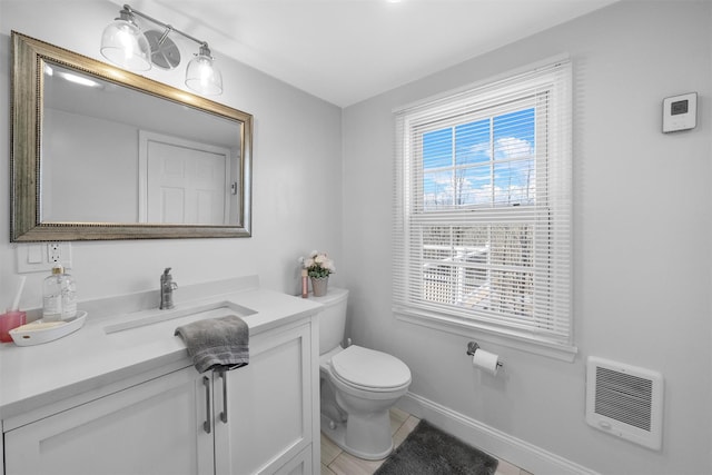 bathroom with tile patterned flooring, vanity, heating unit, and toilet