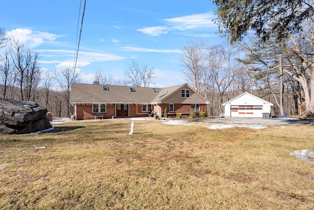 view of front facade featuring an outbuilding, a garage, and a front yard