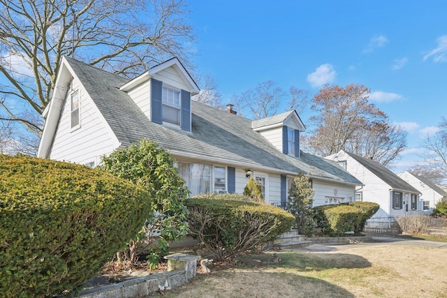 cape cod house with a front lawn