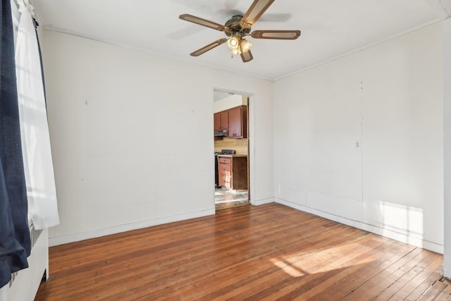 empty room with hardwood / wood-style floors and ceiling fan