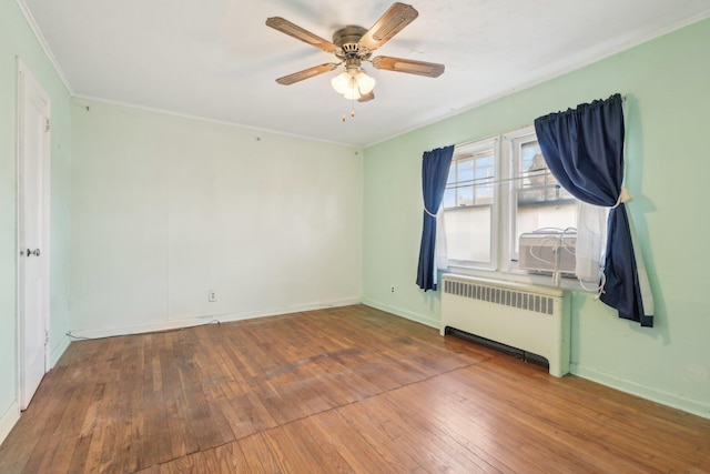 spare room with crown molding, ceiling fan, radiator heating unit, and hardwood / wood-style floors