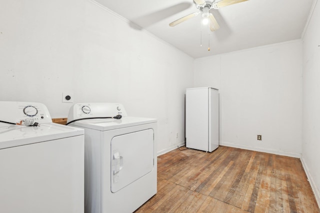 laundry area with washing machine and dryer, ornamental molding, ceiling fan, and light wood-type flooring