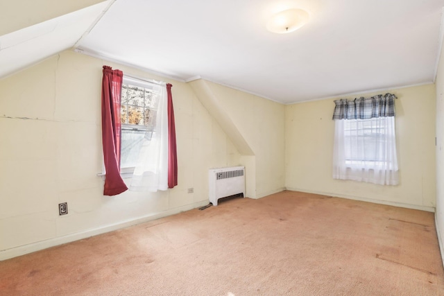 additional living space with vaulted ceiling, carpet, and radiator heating unit