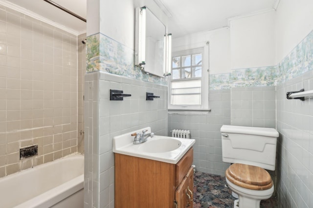 full bathroom with vanity, tiled shower / bath, tile walls, and toilet