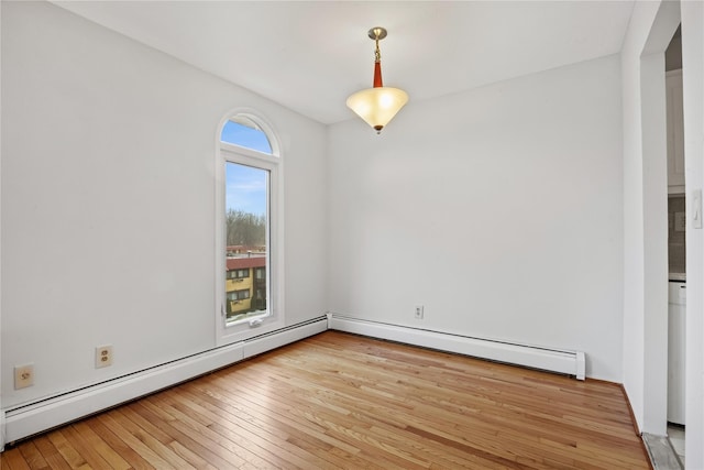 unfurnished room with a baseboard radiator and light hardwood / wood-style floors