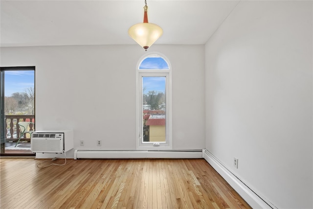 unfurnished room featuring wood-type flooring, an AC wall unit, and baseboard heating