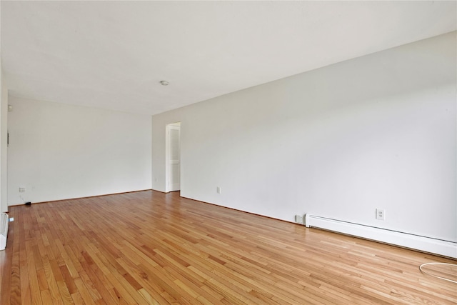 empty room featuring light wood-type flooring and baseboard heating