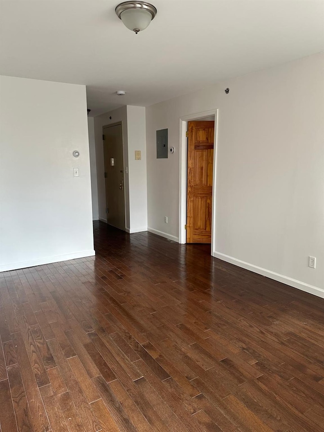 unfurnished room with electric panel and dark hardwood / wood-style floors