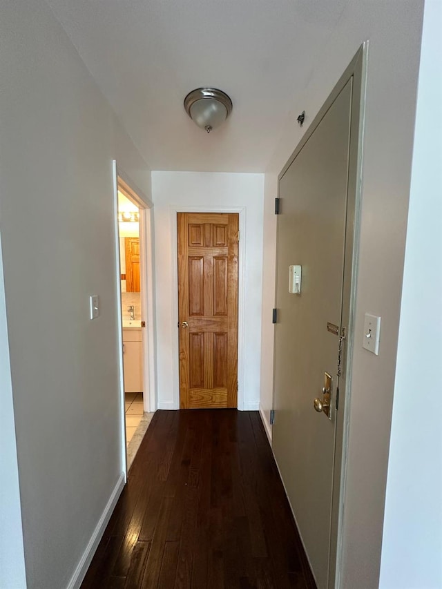 corridor with hardwood / wood-style flooring and sink