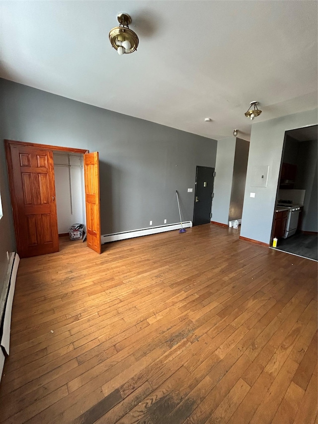 unfurnished living room featuring a baseboard radiator and light hardwood / wood-style flooring