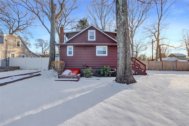 view of snow covered rear of property