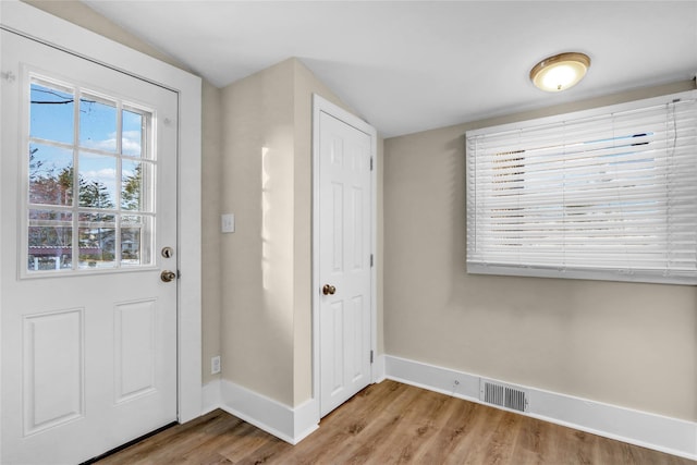 foyer with lofted ceiling and light hardwood / wood-style flooring