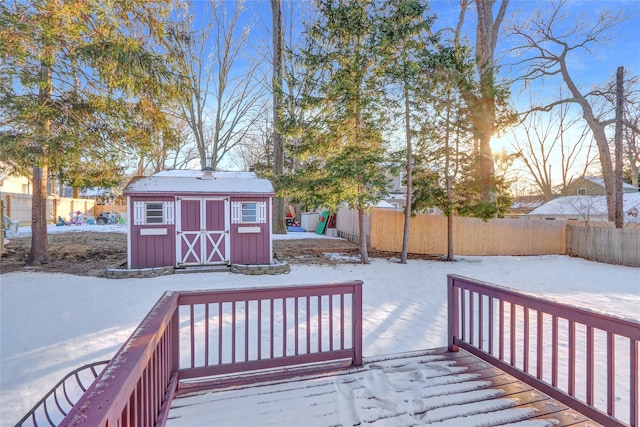 snow covered deck featuring a shed