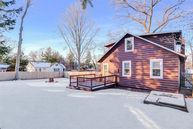 snow covered back of property featuring a deck