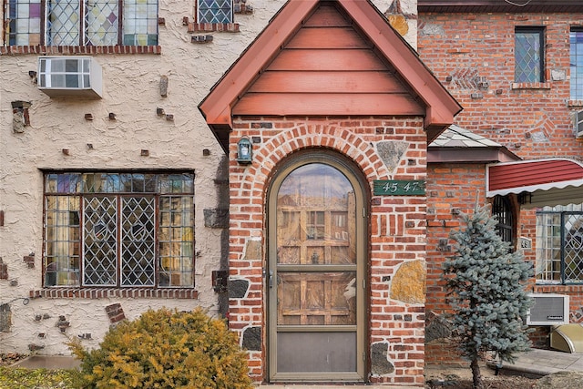 entrance to property with brick siding and stucco siding