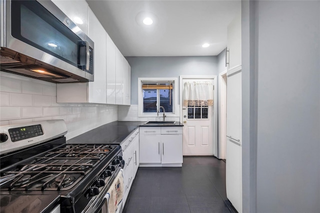 kitchen featuring tasteful backsplash, stainless steel appliances, sink, and white cabinets