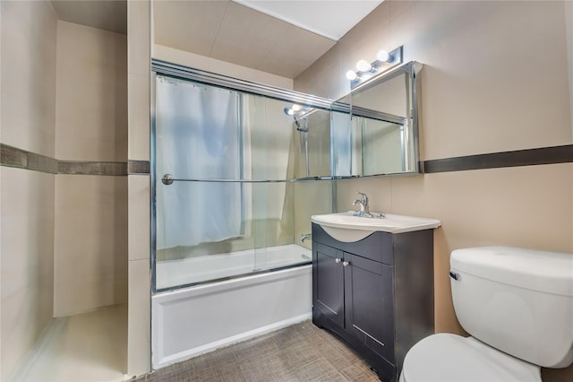 full bathroom featuring vanity, combined bath / shower with glass door, and toilet